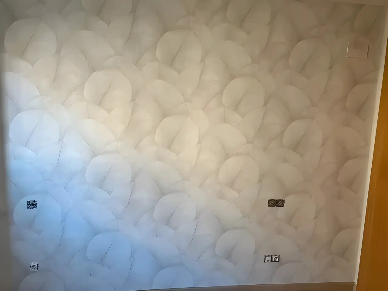 Los Pintores Cáceres aplicando papel pintado de textura clara en salón reformado