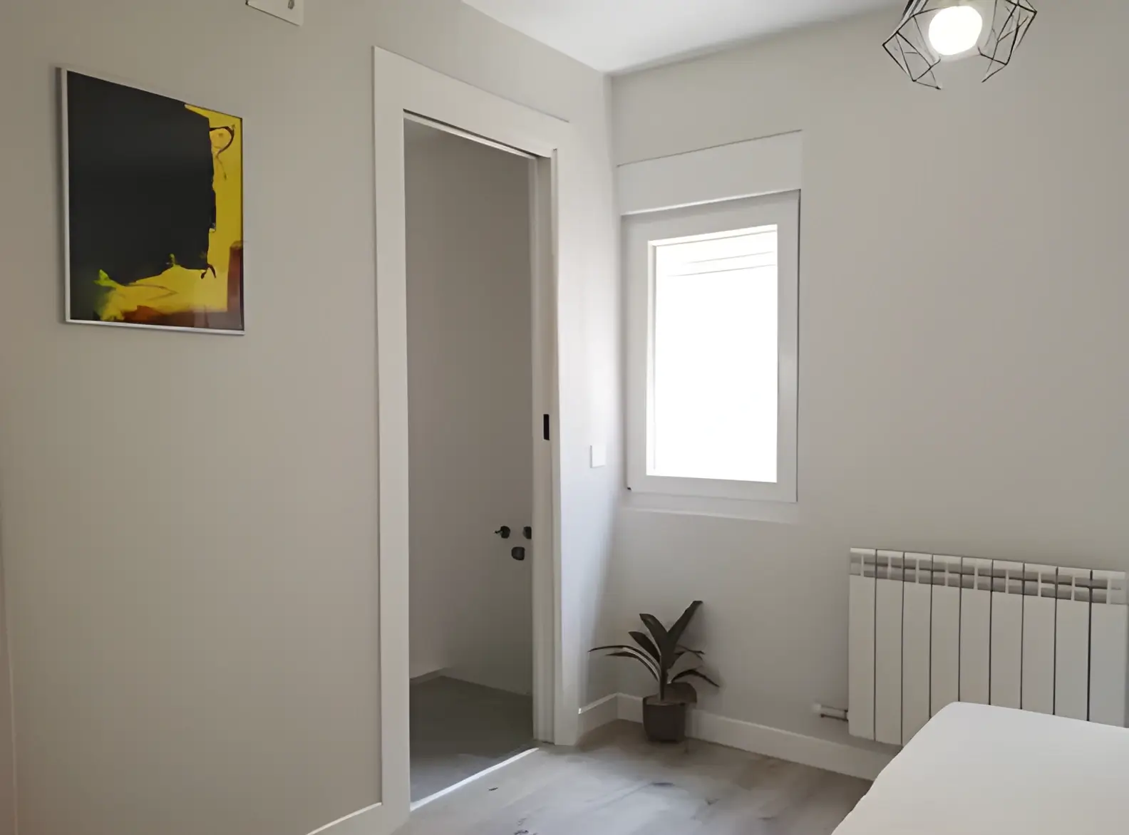 Habitación recién pintada en blanco por Los Pintores Cáceres para comunidad de vecinos